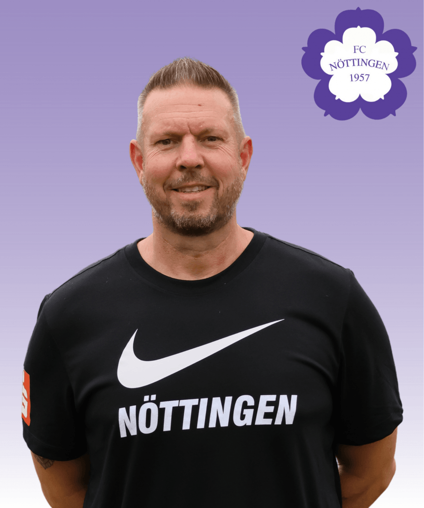 Ein lächelnder Mann in einem schwarzen Nike-Trikot des FC Nöttingen steht vor einem lilafarbenen Hintergrund mit dem Logo des FC Nöttingen 1957