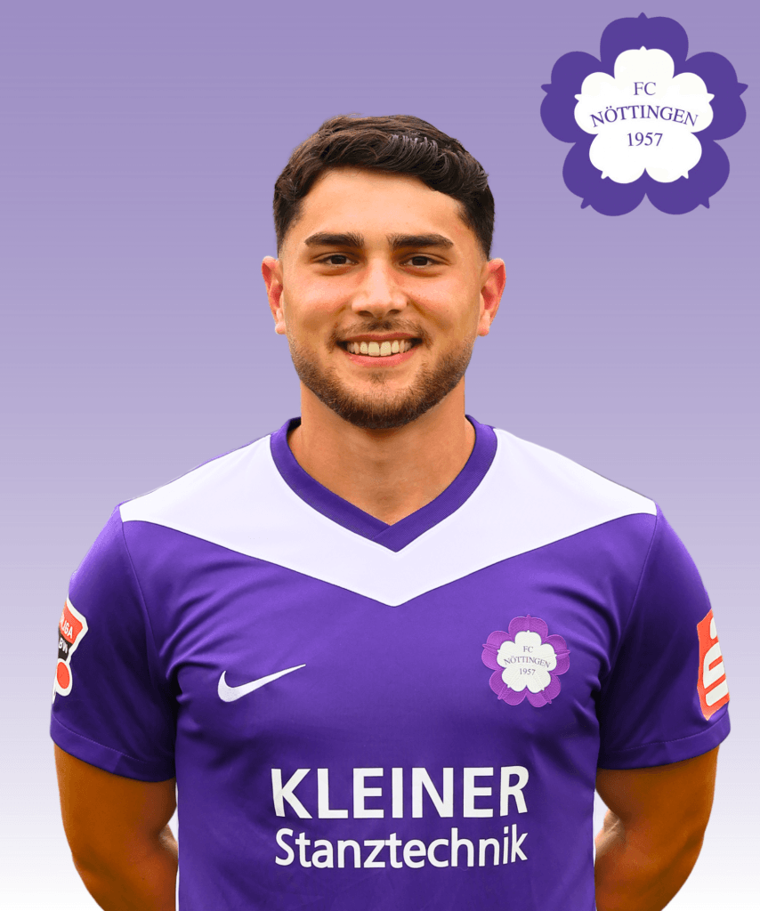 Ein Fußballspieler im lila Trikot des FC Nöttingen lächelt in die Kamera, hinter ihm das Vereinslogo