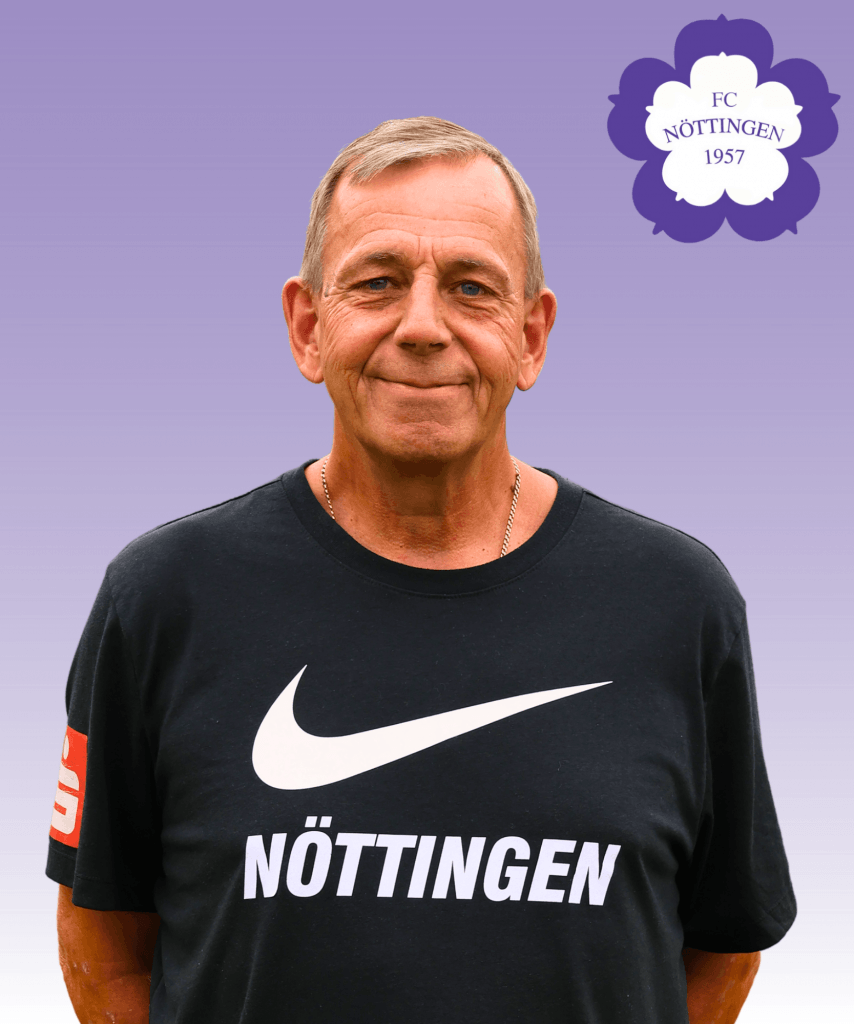 Ein älterer Mann lächelt in einem schwarzen Nike-Trikot von Nöttingen vor einem lilafarbenen Hintergrund mit dem Logo des FC Nöttingen 1957