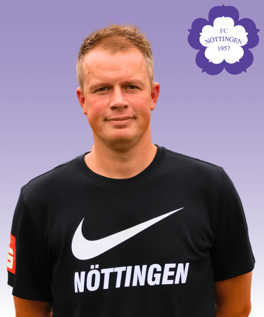 Ein Mann in einem schwarzen Nöttingen-Trikot steht vor einem lilafarbenen Hintergrund mit dem Logo des FC Nöttingen 1957